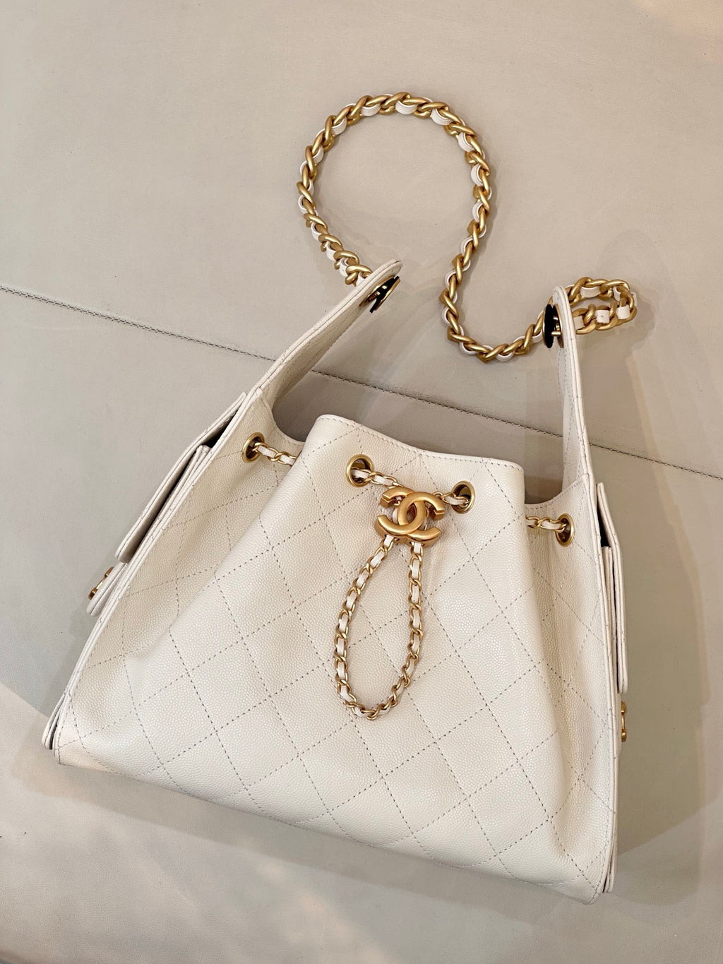 Chanel quilted white leather bucket bag with gold chain strap and CC logo front detail