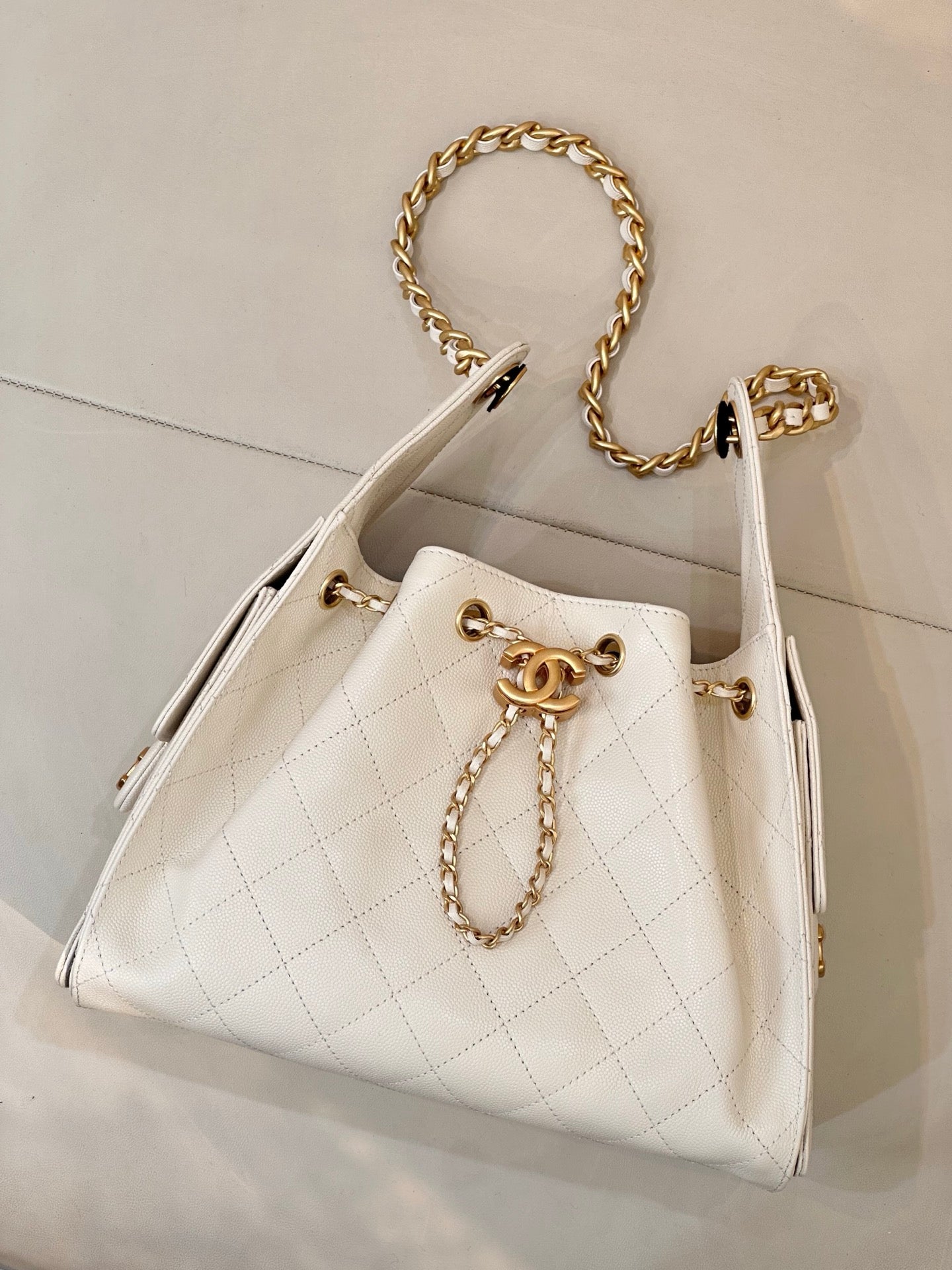 Chanel quilted white leather bucket bag with gold chain strap and CC logo front detail