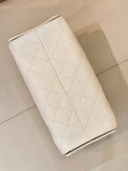 Chanel quilted white leather bucket bag side view with diagonal stitched panel and seam