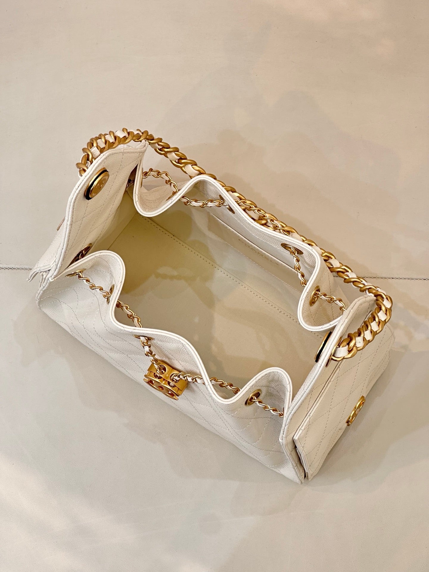 Chanel quilted white leather bucket bag open view with gold chain strap and interior lining