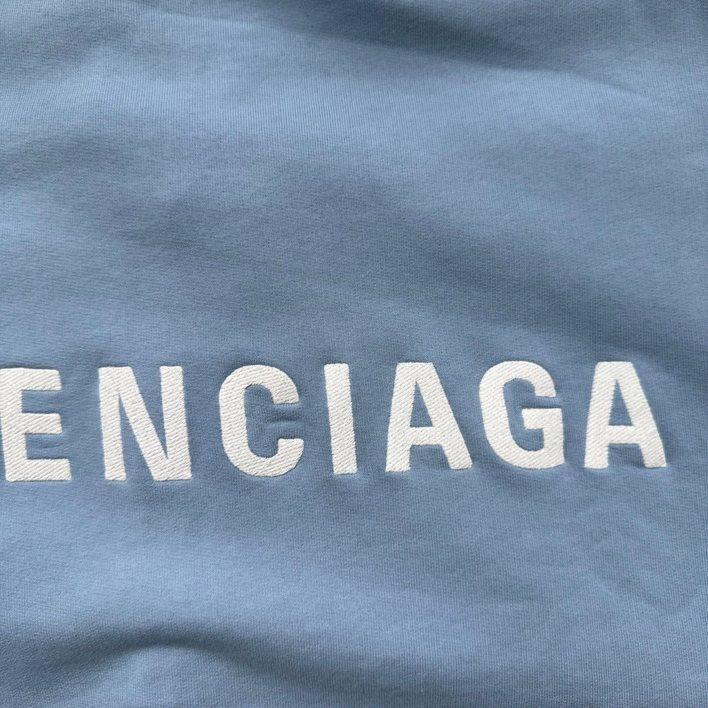 Light blue top with Balenciaga logo lettering, partial 'ENCIAGA' print