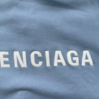 Light blue top with Balenciaga logo lettering, partial 'ENCIAGA' print