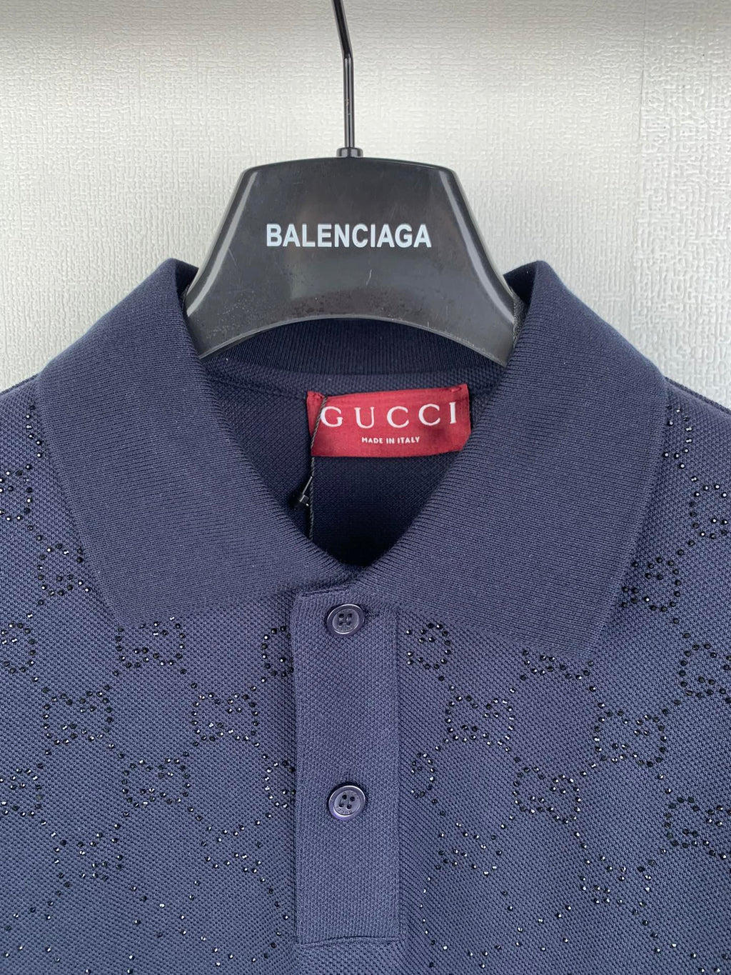 Navy polo shirt collar with two-button placket and red Gucci neck label