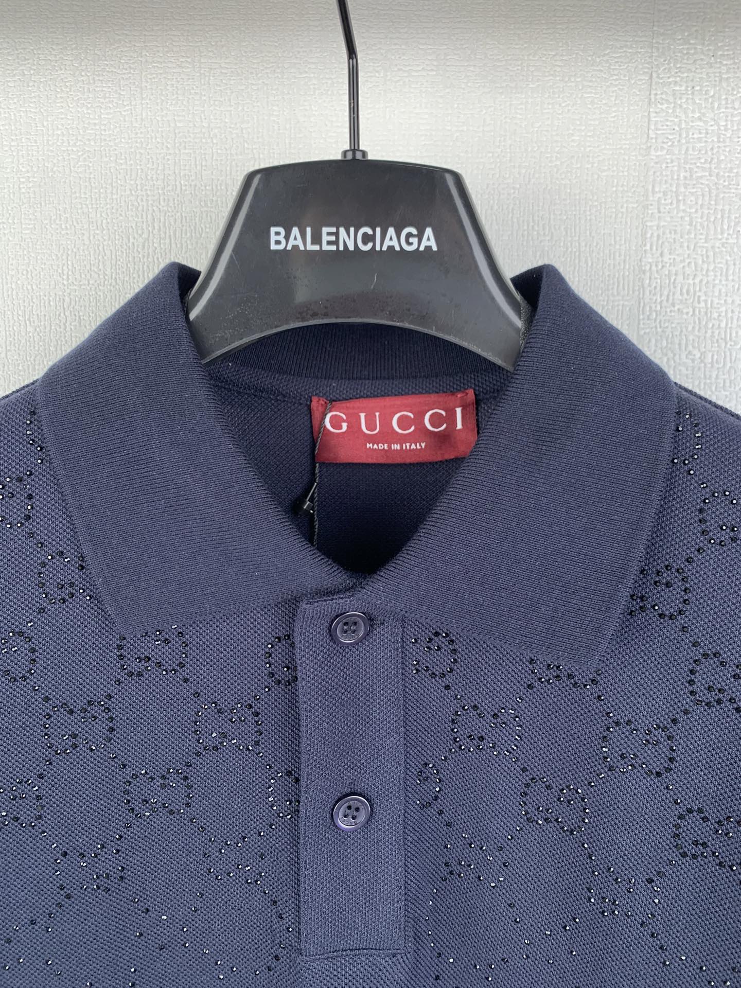 Navy polo shirt collar with two-button placket and red Gucci neck label