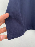 Navy polo shirt sleeve fabric, showing knit texture and hem