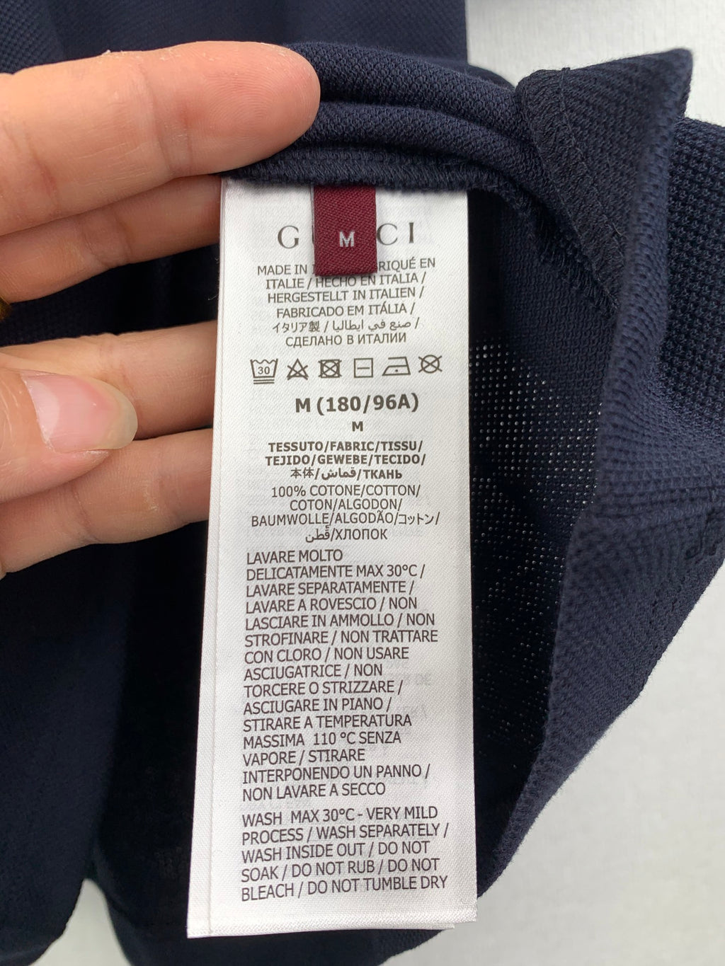 Polo shirt care label showing size and washing instructions