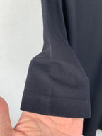 Navy polo shirt sleeve cuff detail with textured fabric and short sleeve hem