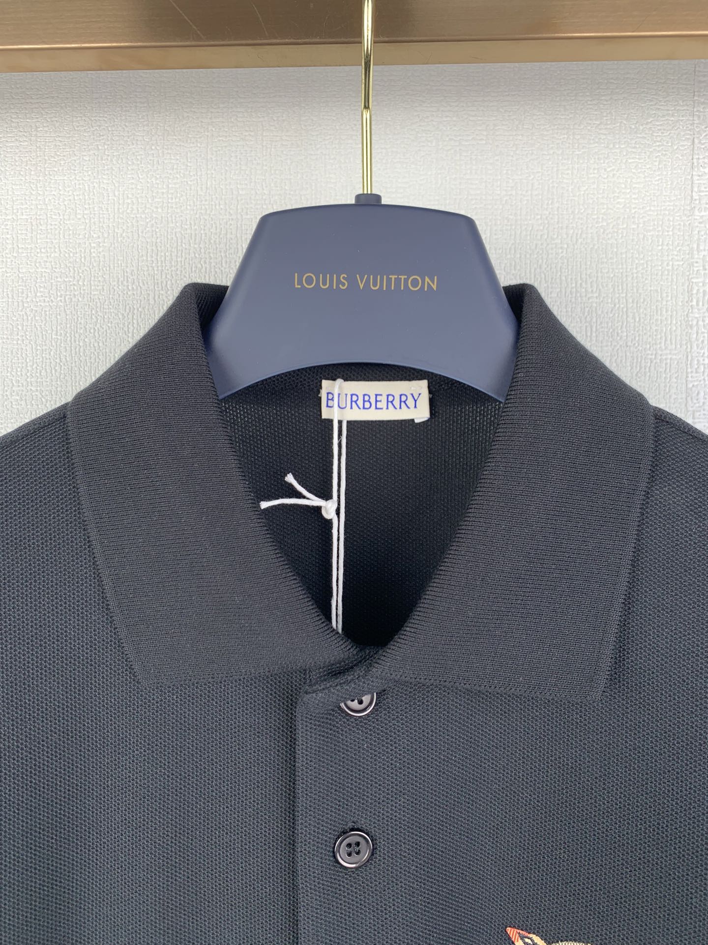 Navy Burberry polo shirt close-up of collar and center logo detail