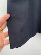 Navy polo shirt fabric close-up with stitched seam along sleeve edge