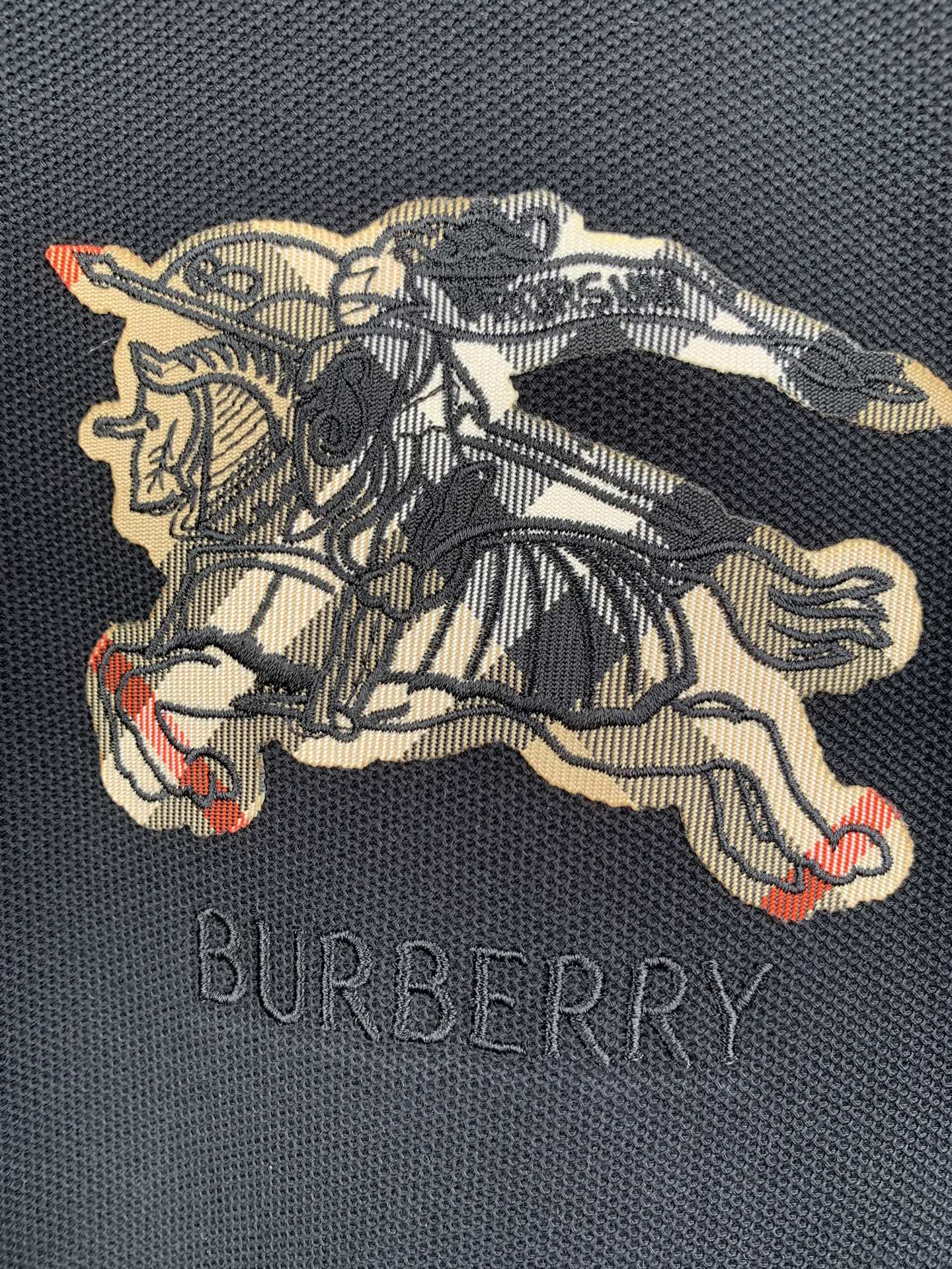 Burberry horse graphic embroidery on navy polo shirt with multicolor accents