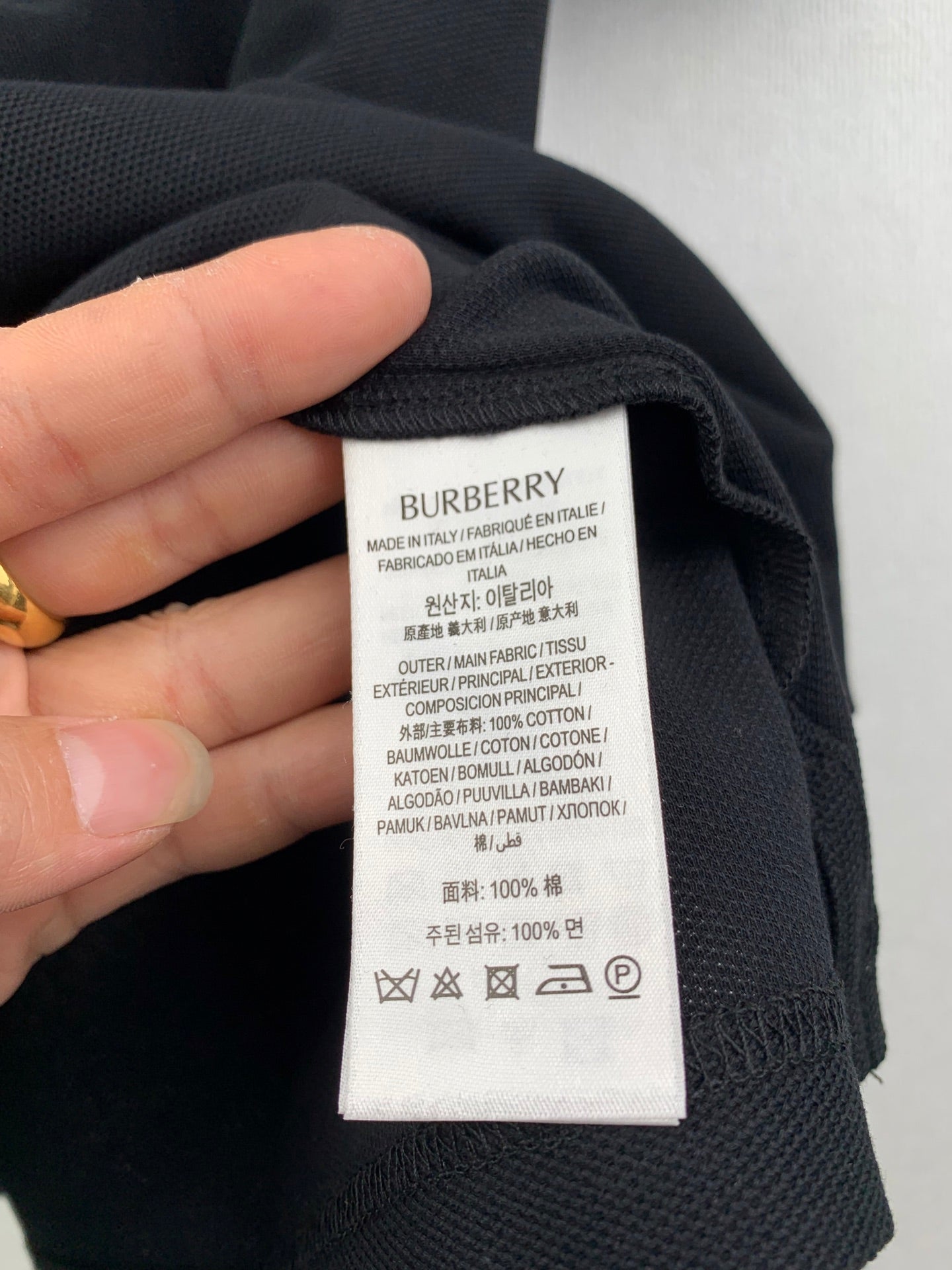 Burberry polo shirt inside neck care label with fabric and washing symbols