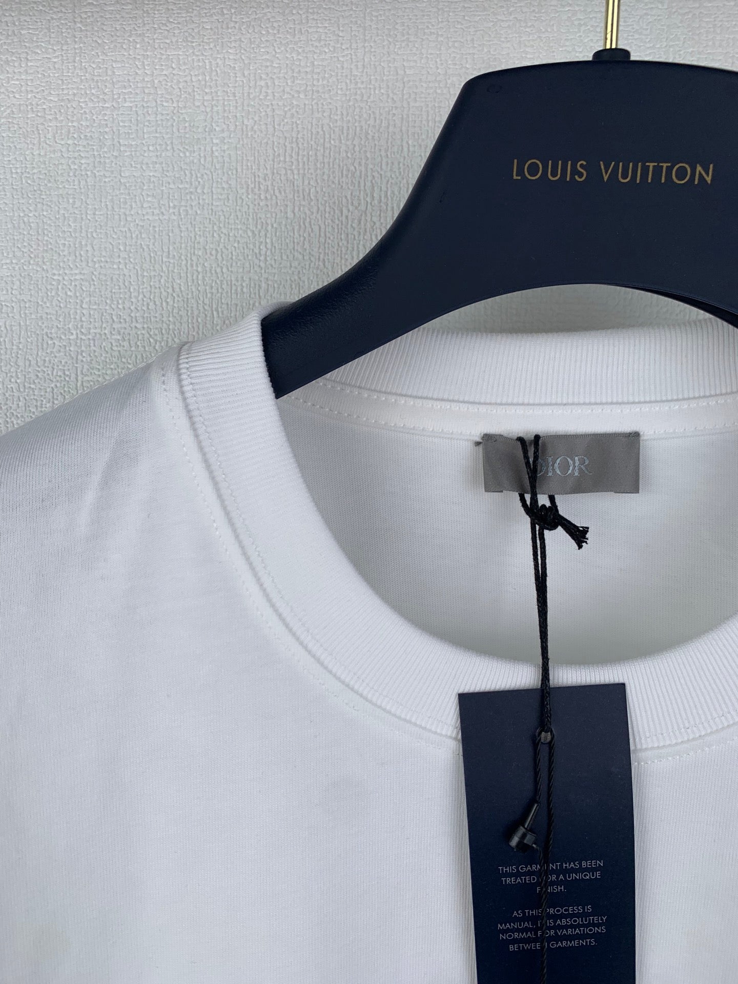 White T-shirt neckline with Dior inner tag hanging from collar