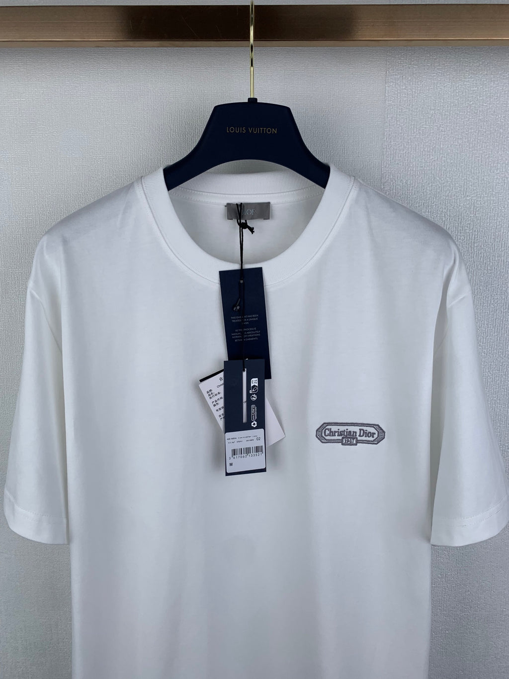 White short-sleeve T-shirt front view with Dior chest logo and size tag