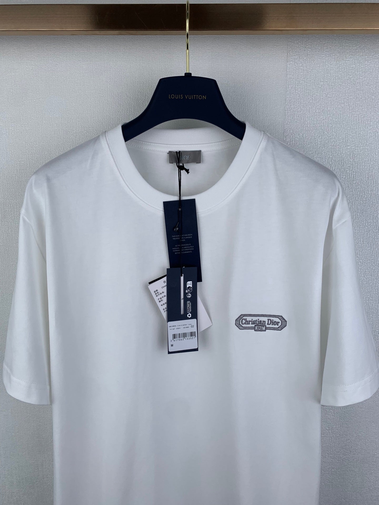 White short-sleeve T-shirt front view with Dior chest logo and size tag