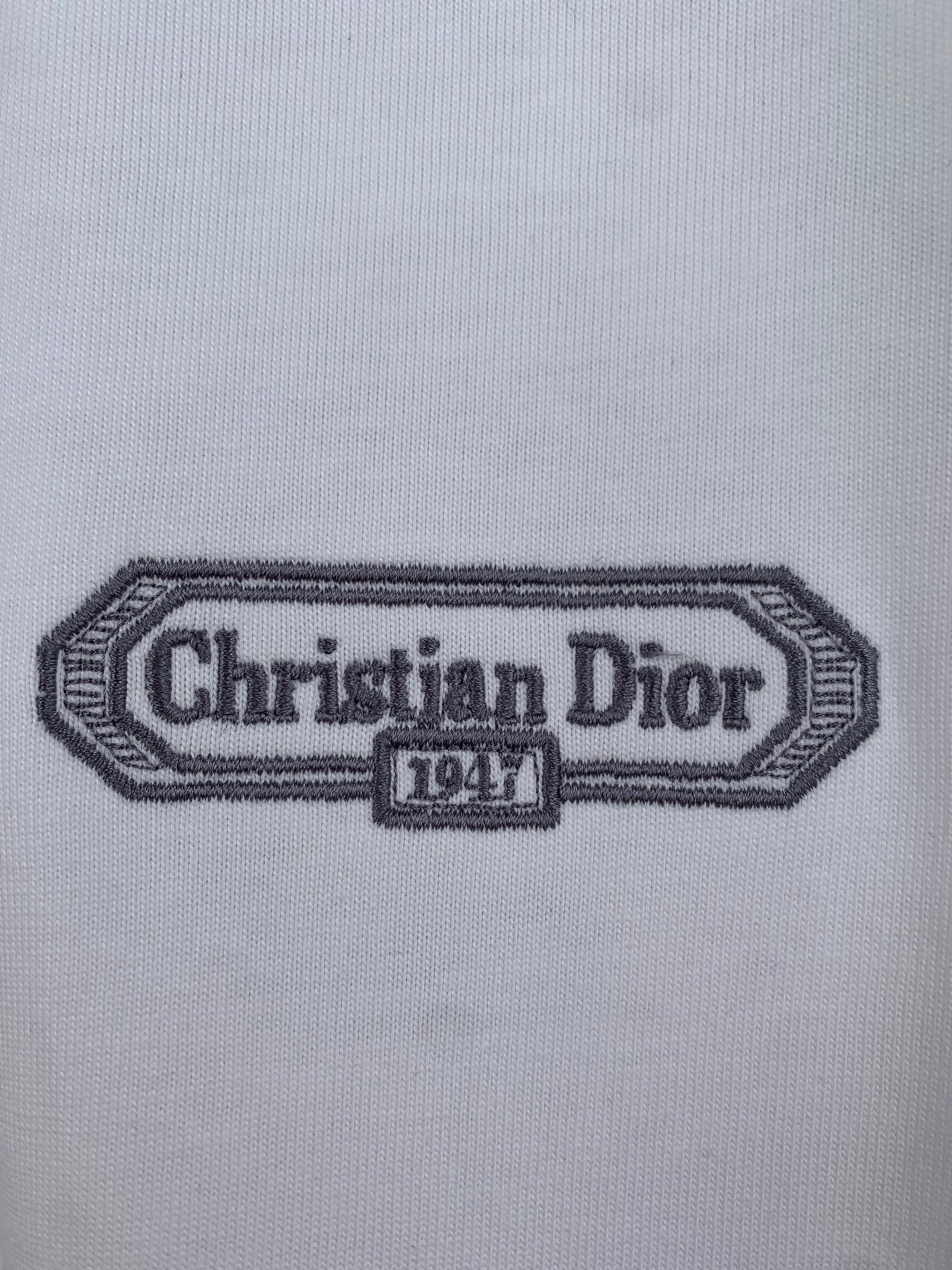 Embroidered Christian Dior 1947 logo patch on white T-shirt