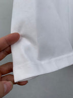 White T-shirt sleeve cuff seam detail held by hand
