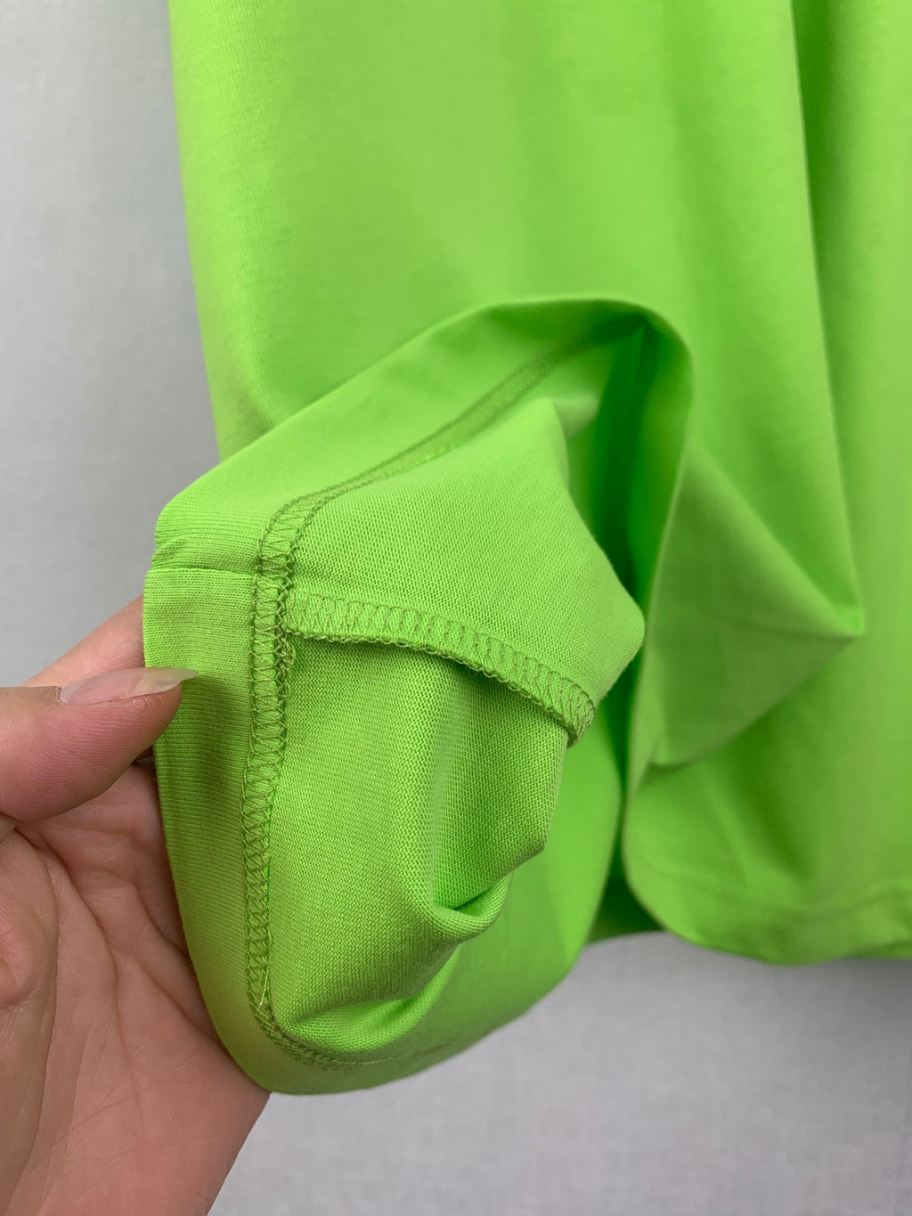 Neon green T-shirt sleeve cuff with reinforced stitching