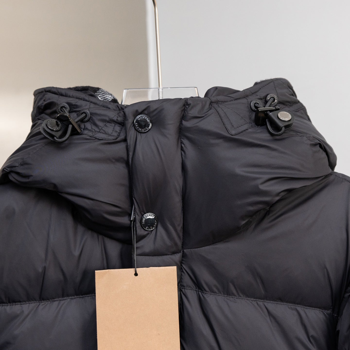 Black hooded puffer jacket hood with drawcord and snap buttons