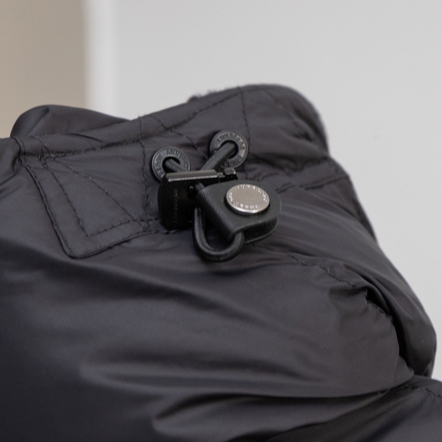 Black puffer jacket hood attachment with drawcord and snap hardware