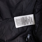 Long black puffer jacket showing Burberry fabric tag and zip pocket