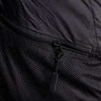 Black puffer vest pocket with mesh fabric and exposed zipper pull