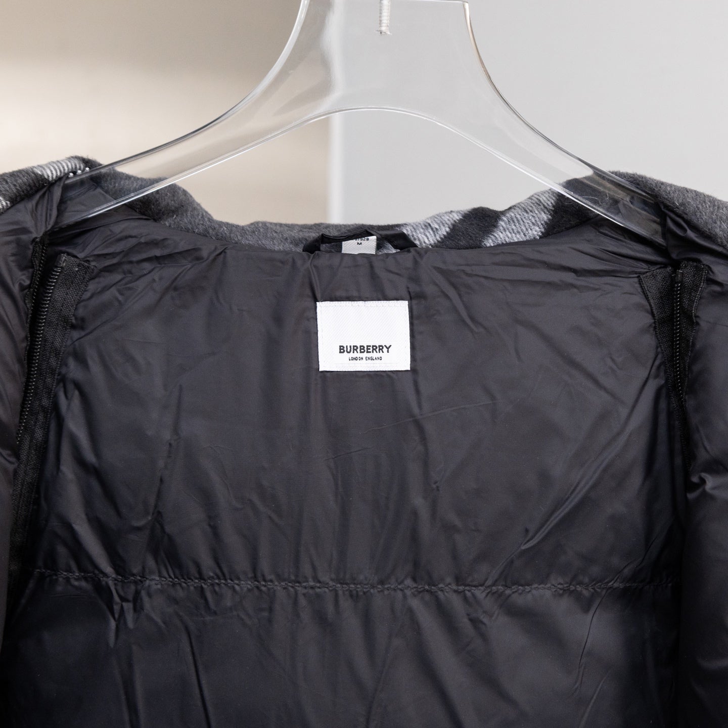 Black hooded puffer jacket interior lining view with Burberry neck label