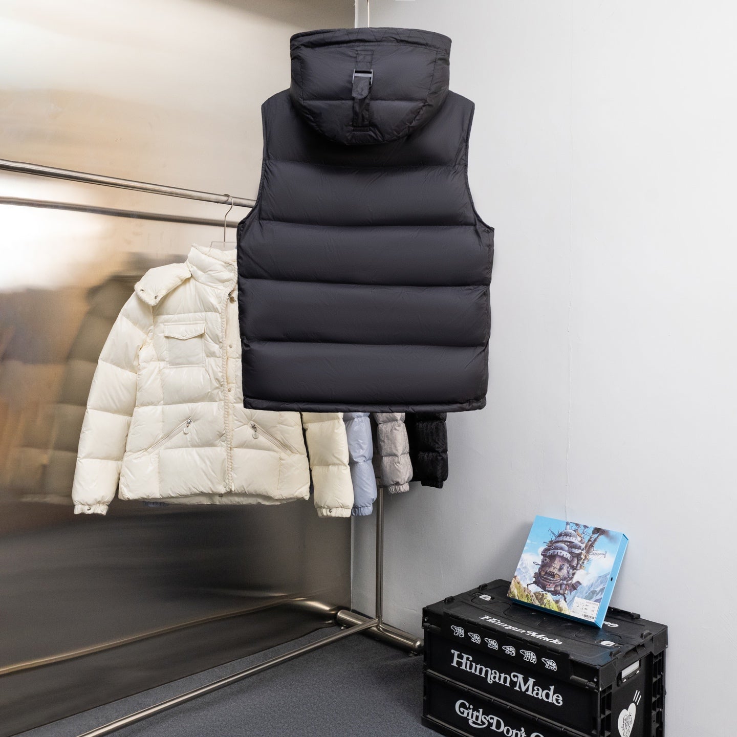 Black hooded puffer vest with high collar and sleeveless quilted baffles