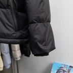 Black puffer vest with elastic cuff hem and quilted side paneling