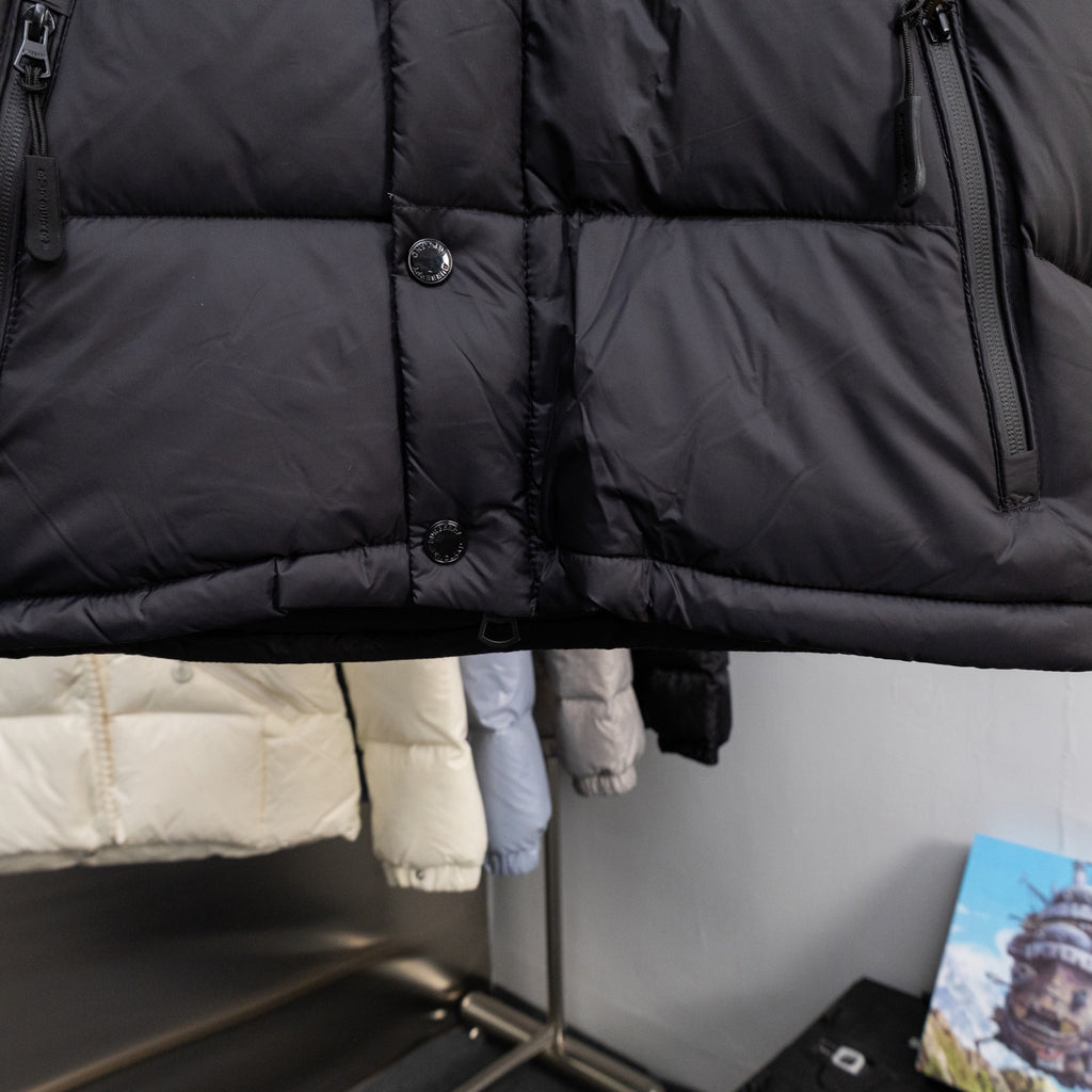 Long black puffer jacket with front buttons and quilted panels