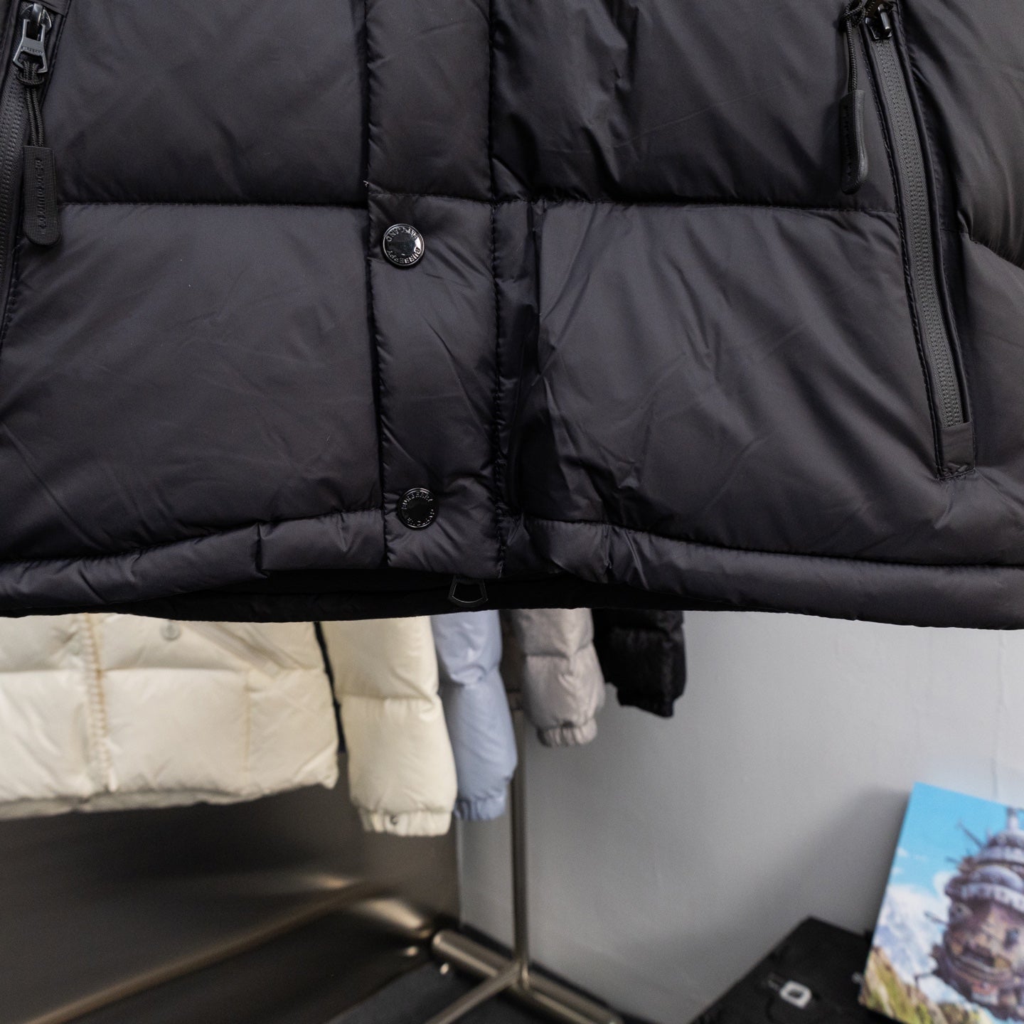 Long black puffer jacket with front buttons and quilted panels