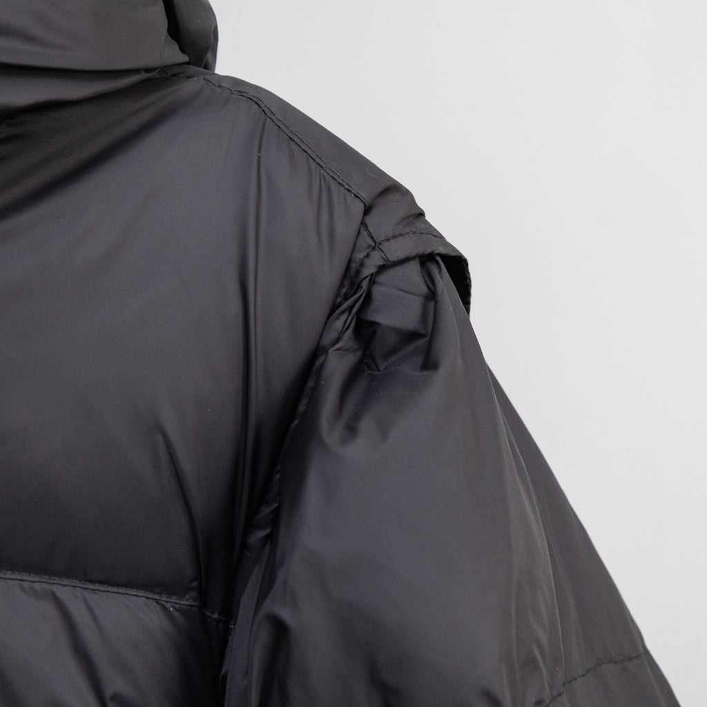 Black puffer jacket side view with seam stitching and smooth outer fabric