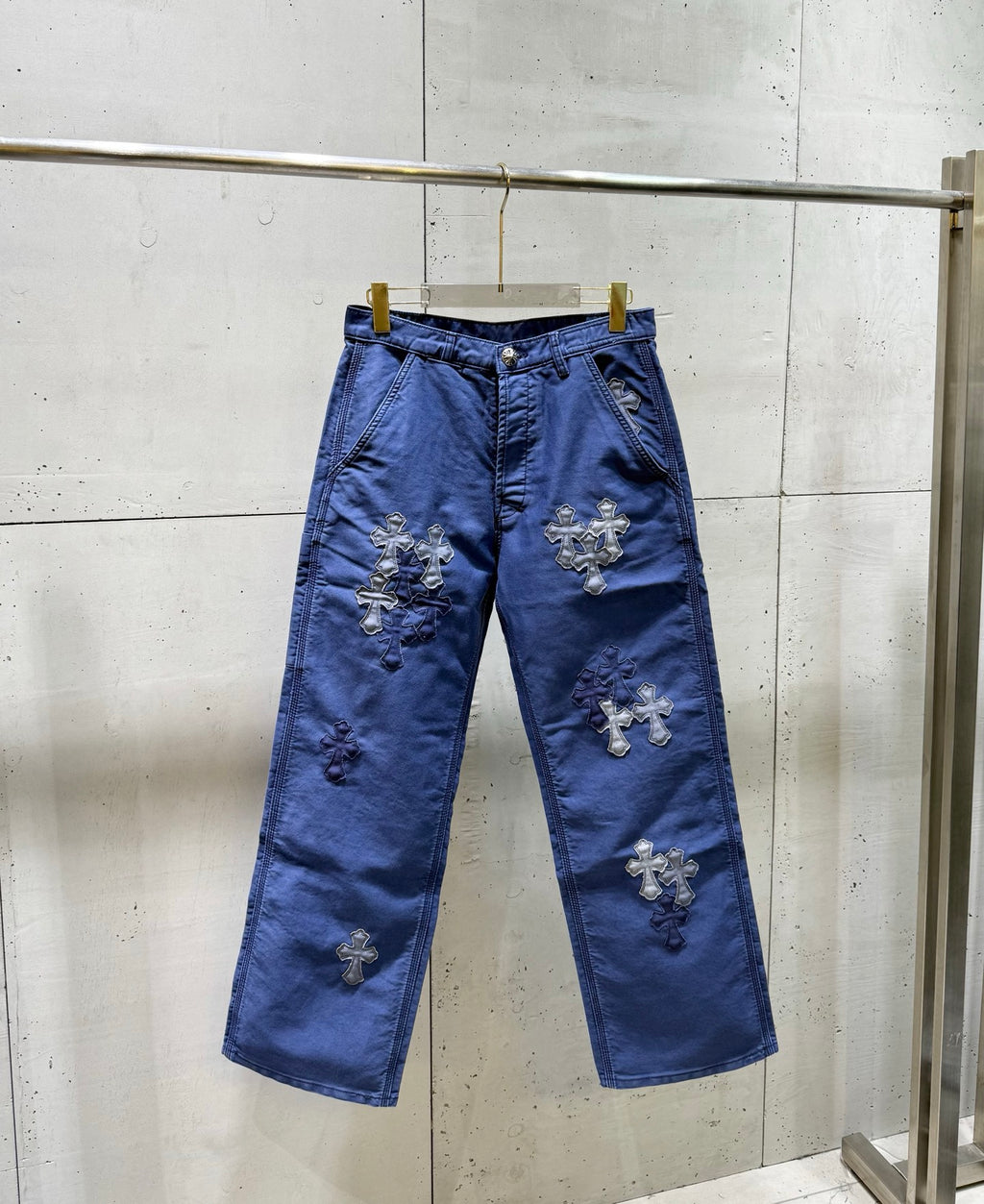 Blue pants with stitched cross appliques on both legs