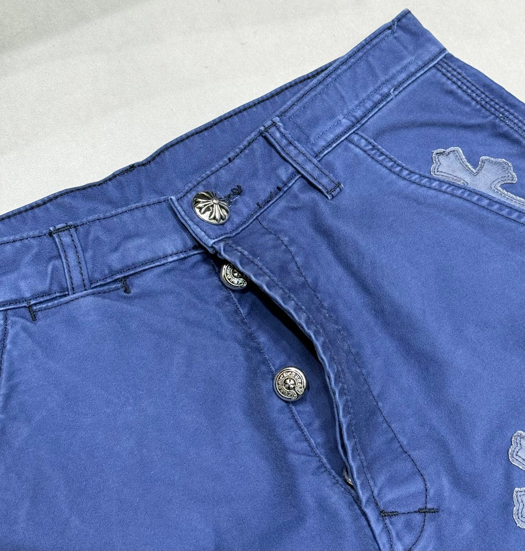 Blue pants front with snap buttons and cross applique detail