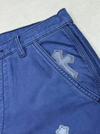 Blue pants with embroidered cross patch near side seam