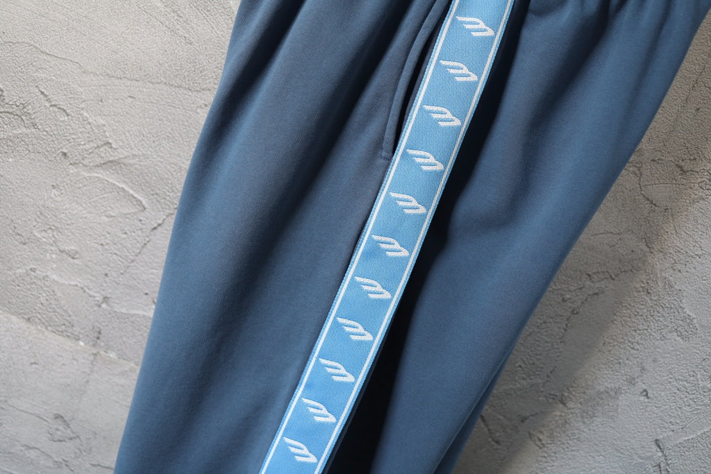 Blue pants with contrast side stripe trim along the leg