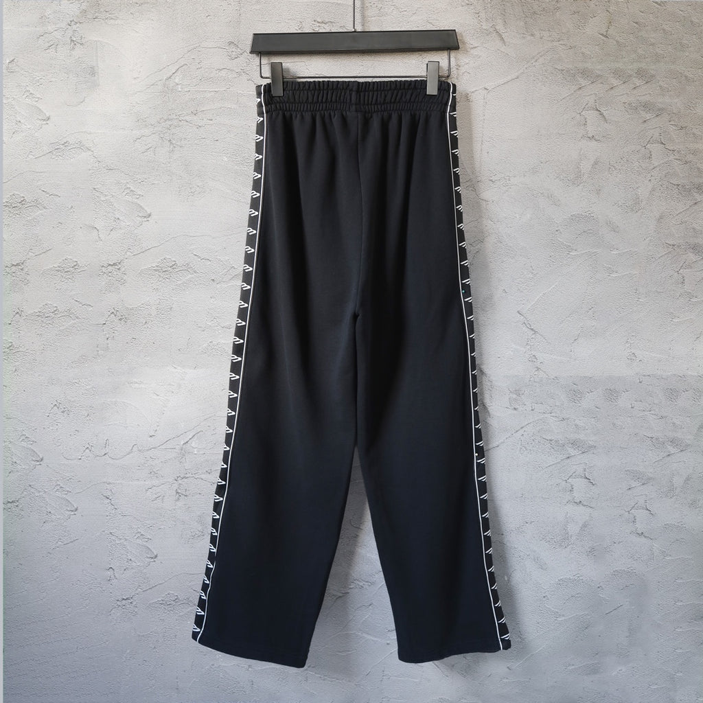 Balenciaga black track pants with side stripe, elastic waist, and wide leg