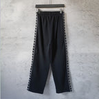Balenciaga black track pants with side stripe, elastic waist, and wide leg