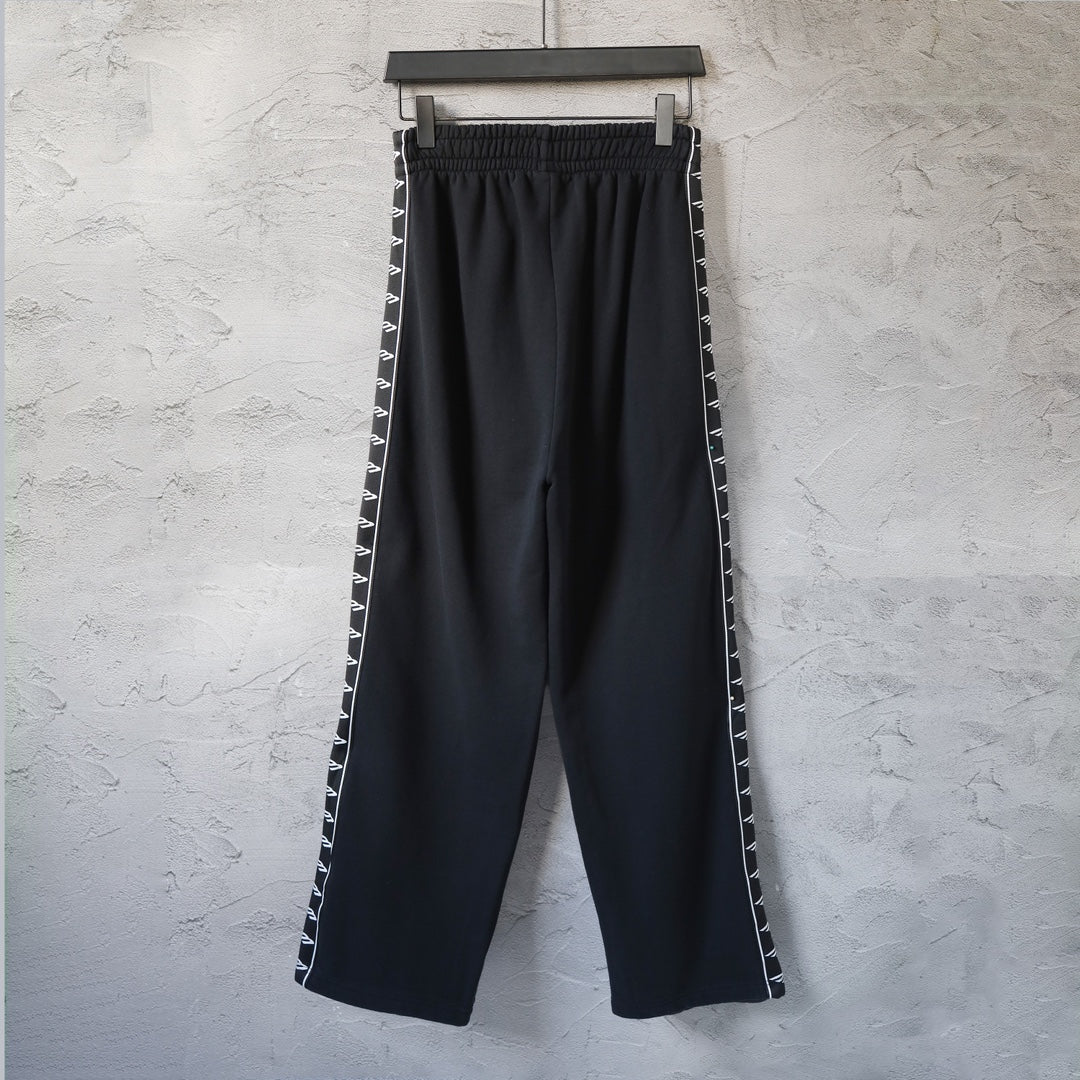 Balenciaga black track pants with side stripe, elastic waist, and wide leg