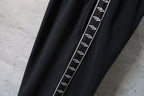 Balenciaga black pants with contrast side stripe and repeating logo print