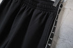 Balenciaga black shorts with contrast logo stripe at side seam and cuff edge