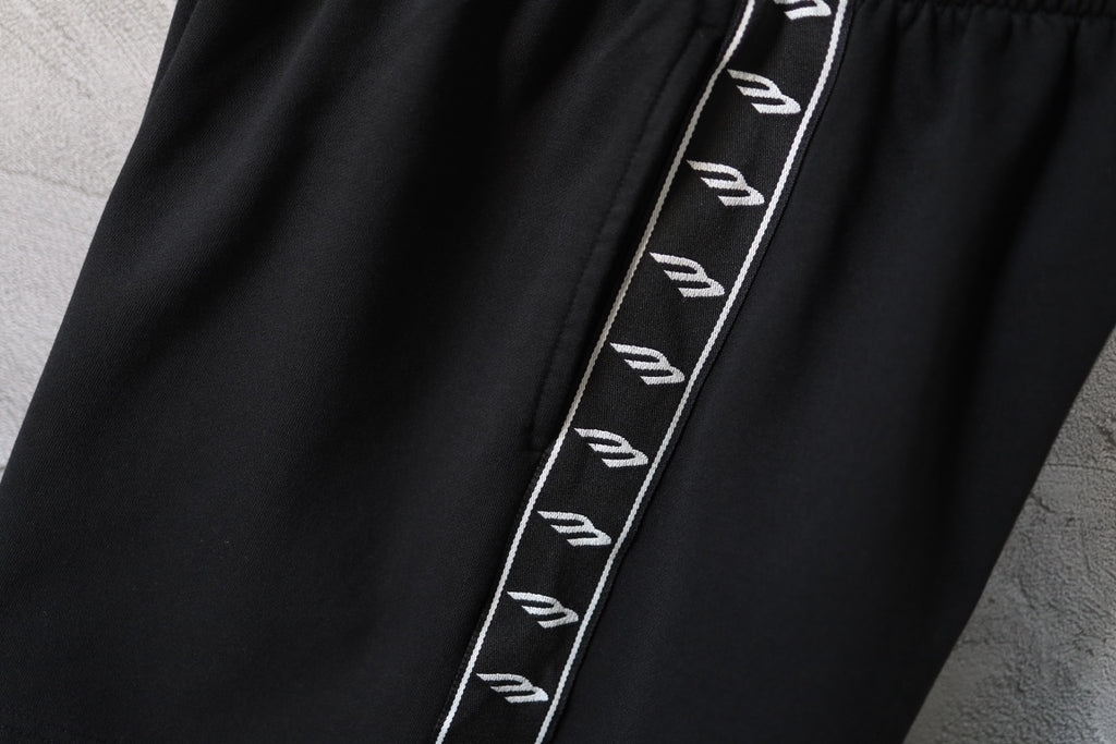Balenciaga black shorts close-up with contrast logo stripe along side seam