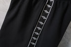 Balenciaga black shorts close-up with contrast logo stripe along side seam