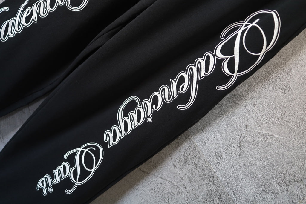 Black pants leg with large white script logo print