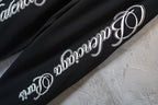 Black pants leg with large white script logo print