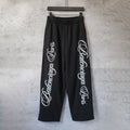 Black wide-leg pants with elastic waistband and white script logo print