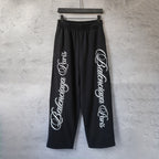 Black wide-leg pants with elastic waistband and white script logo print