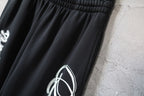 Balenciaga black pants leg with partial white script logo detail