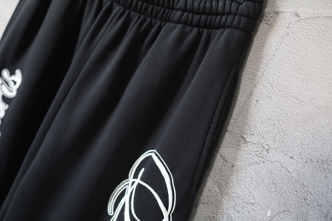 Balenciaga black pants leg with partial white script logo detail