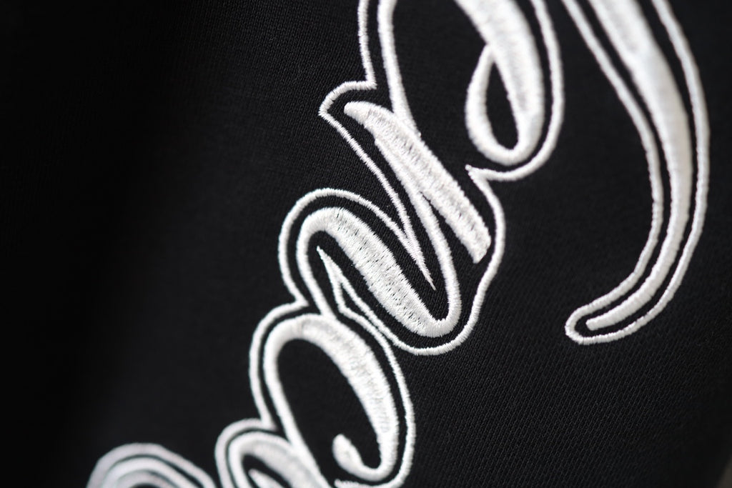 Balenciaga black pants with close-up white embroidered script logo