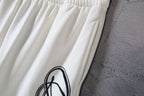White Balenciaga pants with ribbed elastic waist and black logo print